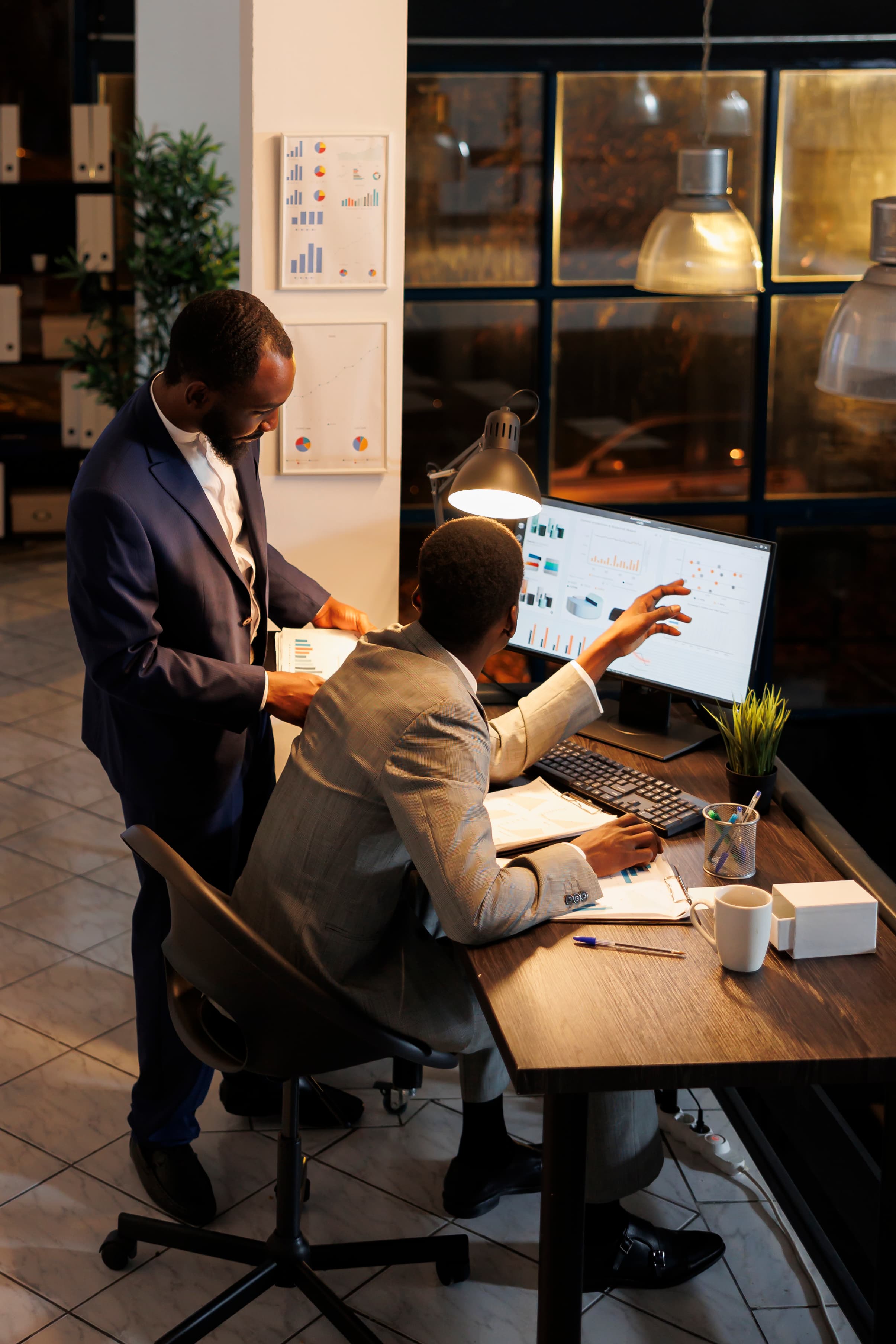 Two colleagues carefully reviewing a financial growth report on a monitor.